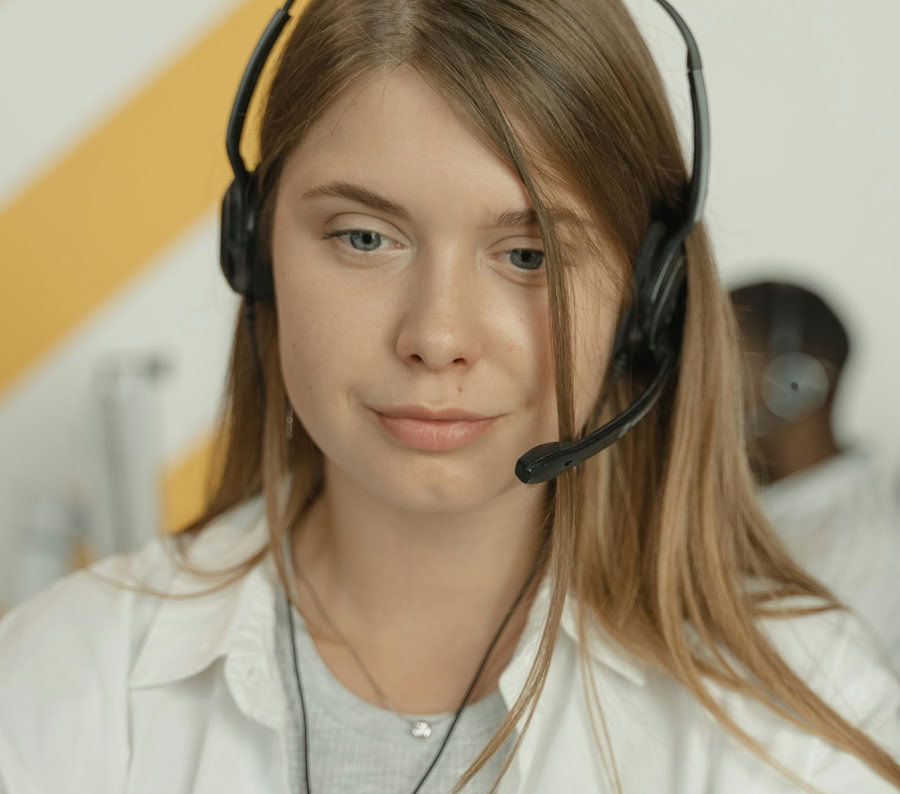 Professional woman wearing headphones, providing excellent customer service in a modern office setting.