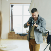 Photographer reviewing camera while setting up a shot in a studio.