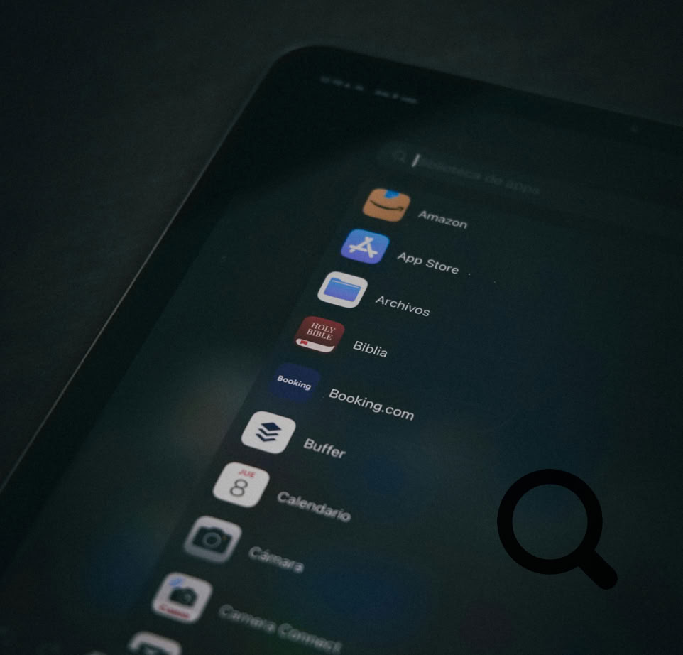 Dark themed close-up of a tablet screen displaying various applications in a vertical shot.